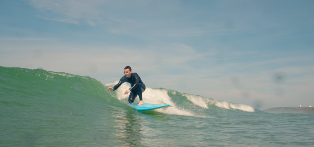 bude surfing. man surfing a green wave.