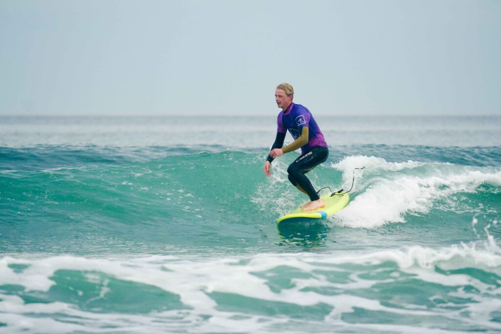 surf lessons. Surfer tracking along a small unbroken wave.