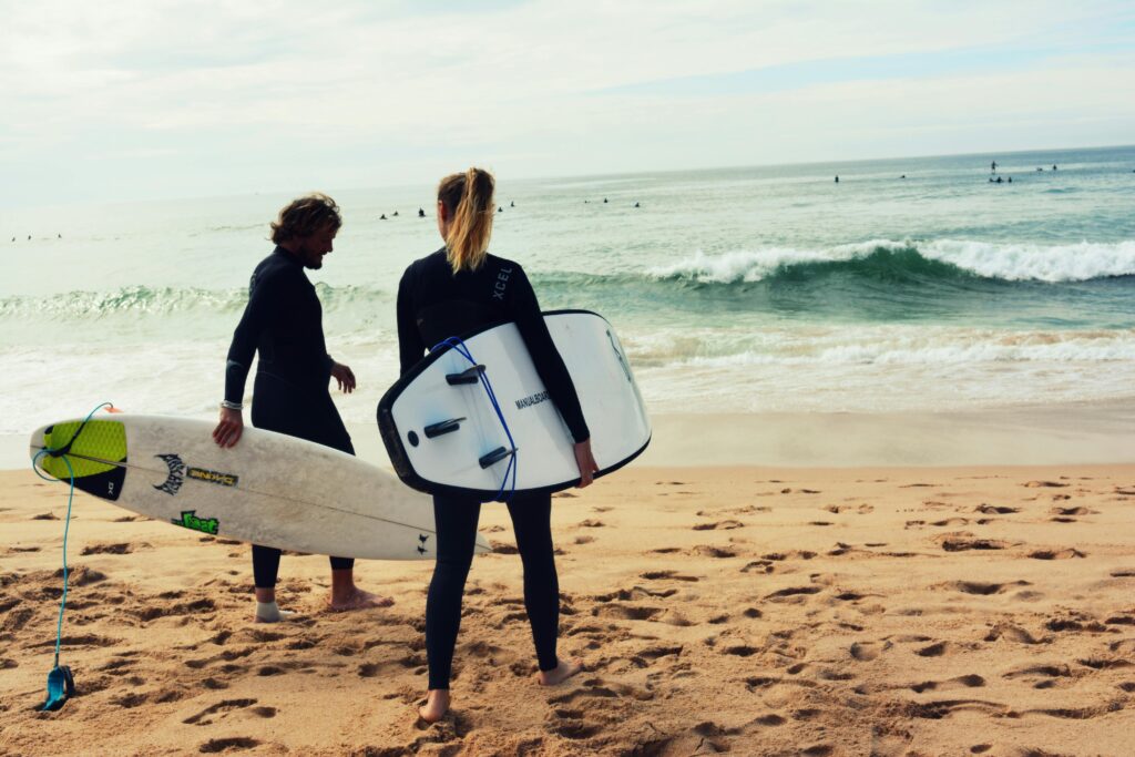 surfing uk. Two surfers at the waters edge holding their boards.