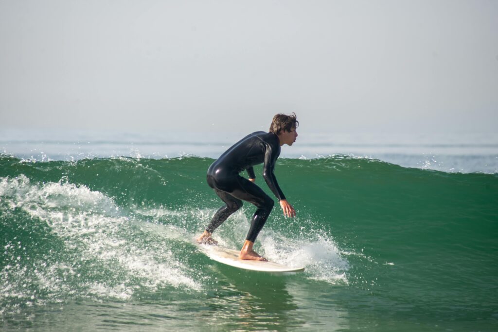 surf boarding wave surfing. surfer riding a green wave.