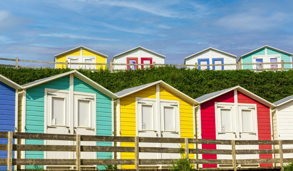 best place for surfing in uk. Colourful beach huts at summerleaze beach.