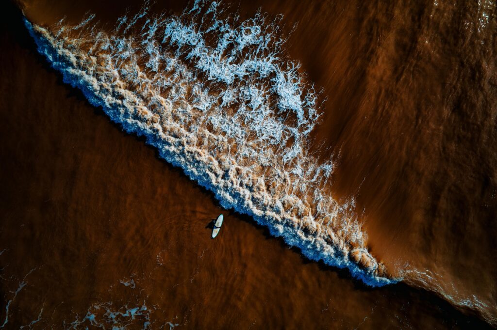 surfing in england. A birds eye view of a surfer in the waves.