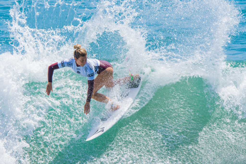 surfing women. female surfer throwing some spray off the back of a wave.