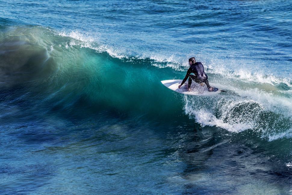 surfing surf. surfer racing down the line of a blue green wave.